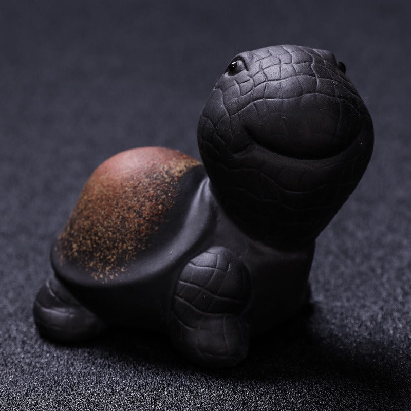 Yixing Clay Tortoise Tea Pet placed elegantly on a tea tray, highlighting its role as a unique tea accessory.