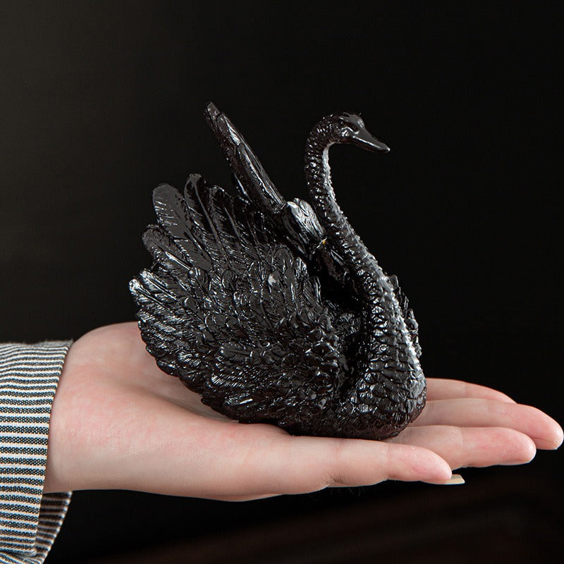 A tea lover pouring leftover tea over the swan tea pet during a ceremony.