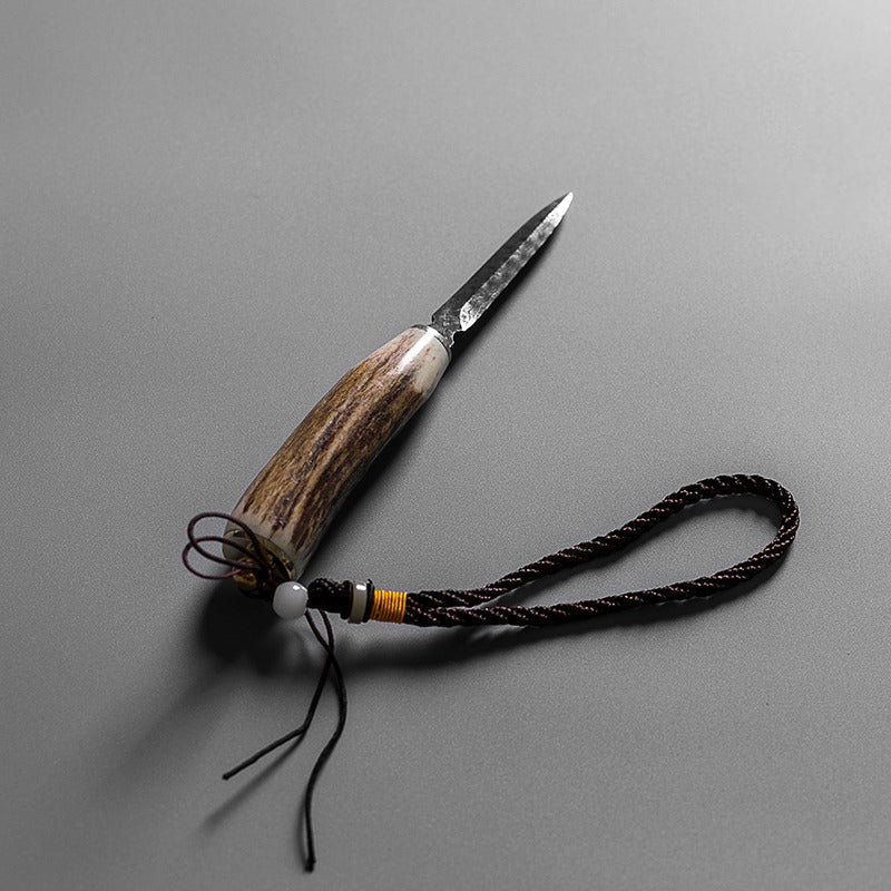 Close-up of handcrafted poplar wood tea knife with leather case for prying compressed tea
