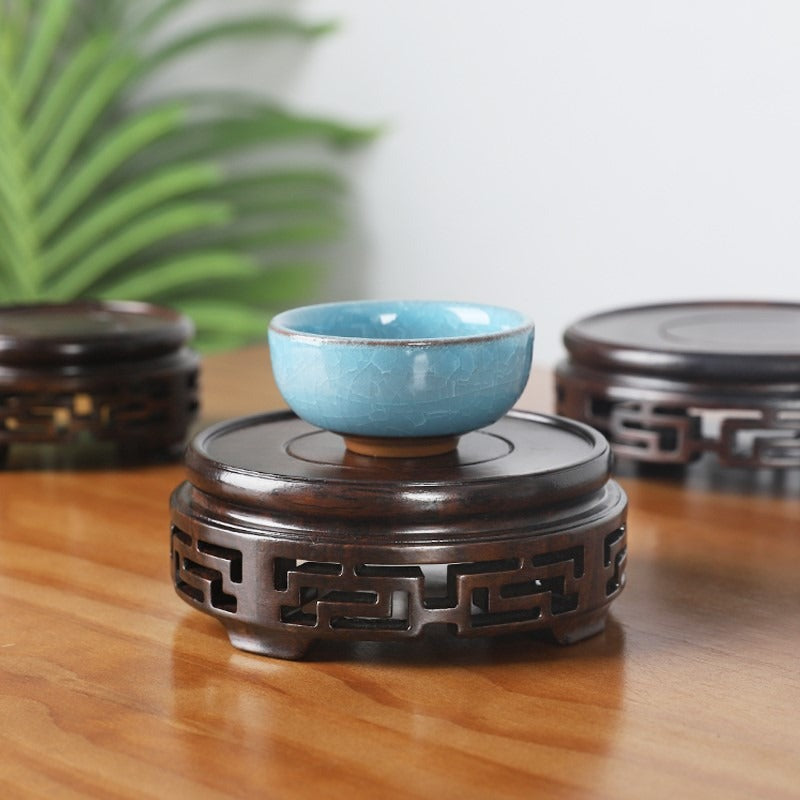 Close-up of ebony wood teapot stand showing its dark, polished surface and craftsmanship
