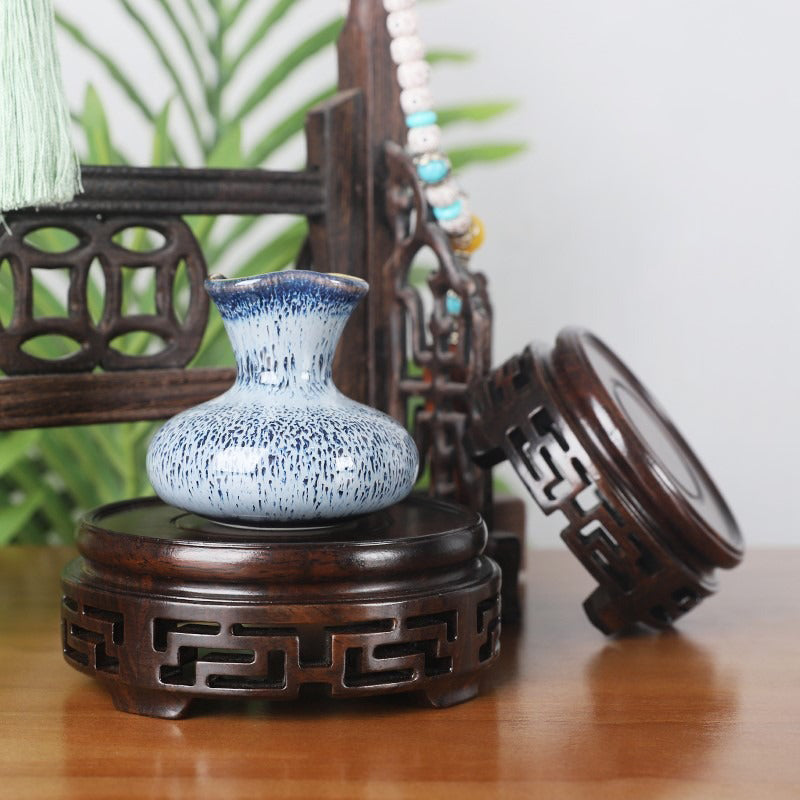 Teapot sitting on a stylish ebony wood stand, ideal for unique kitchen decor items
