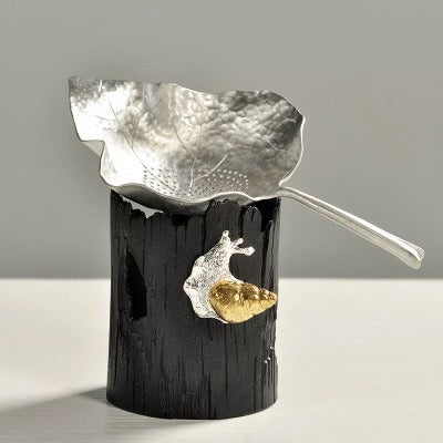 Close-up of Leaf Tin Tea Strainer with Holder showcasing its design and filter mesh