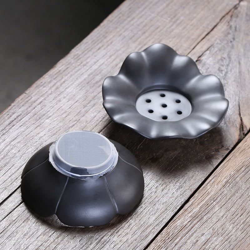 Close-up of lotus-shaped black clay tea filter showing texture and design