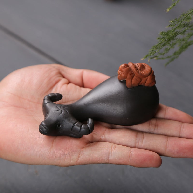 Tea lover pouring leftover tea onto Yixing clay tea pet for maintenance