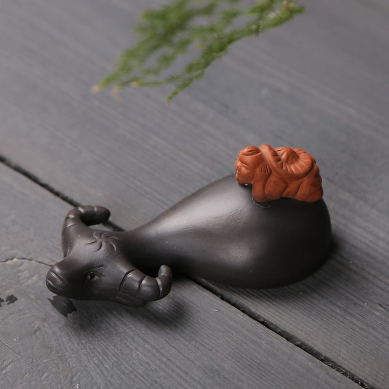 Tea lover pouring leftover tea onto Yixing clay tea pet for maintenance