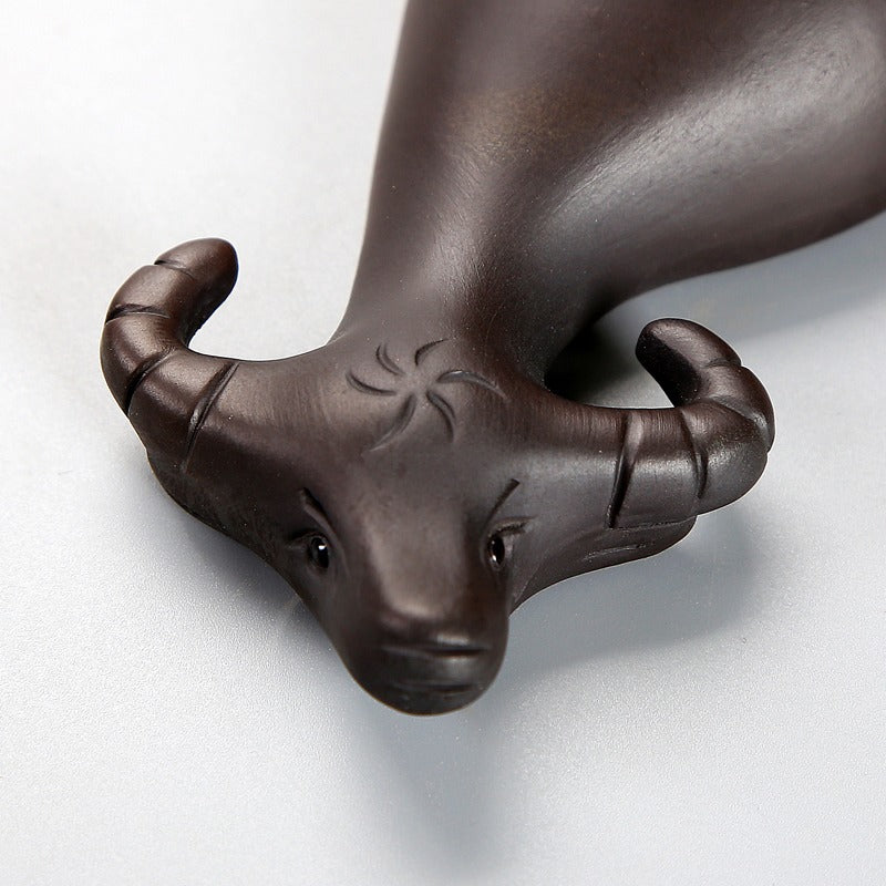 Front view of Yixing clay cow & boy tea pet on tea tray showing detailed craftsmanship