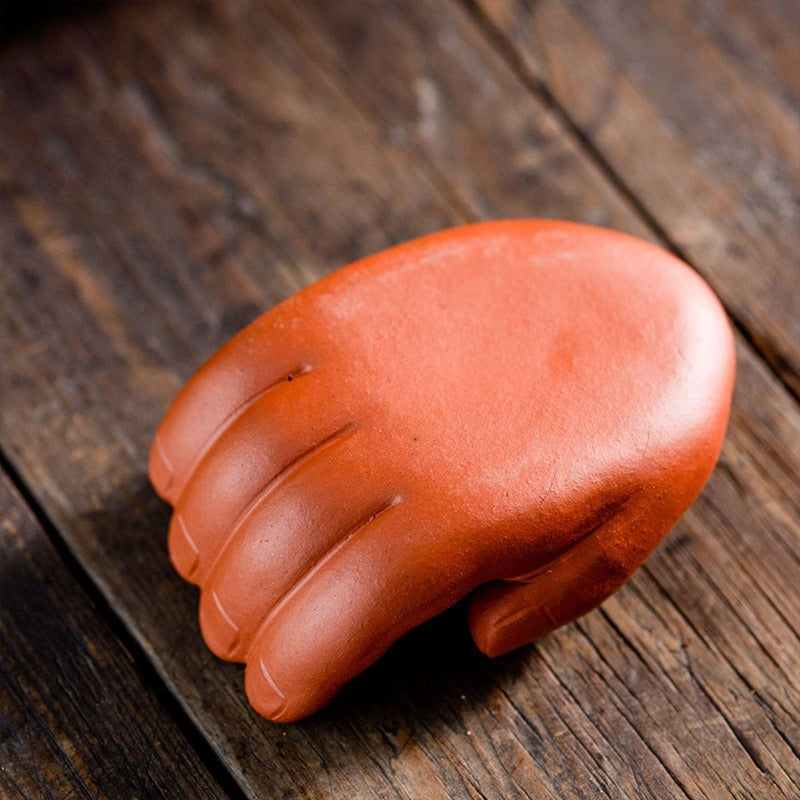 Close-up of a purple clay tea pet being cared for during a tea ceremony