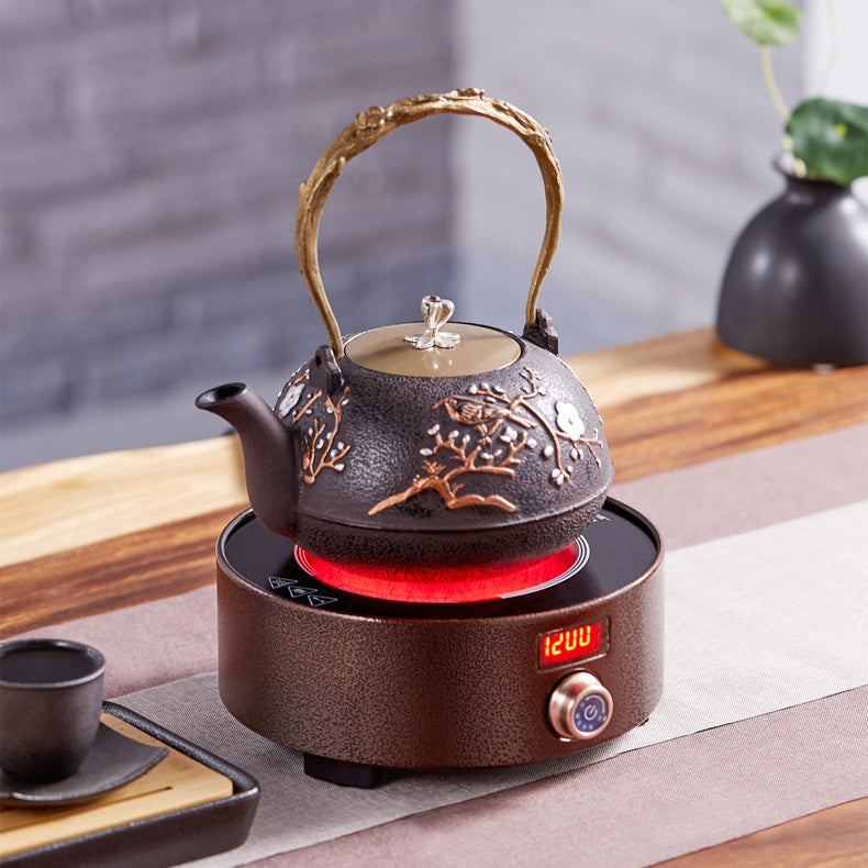 Close-up of cast iron induction teapot warmer with steaming black tea