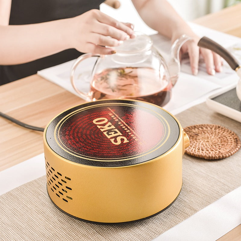 User placing a teapot on the induction cooker tea warmer for heating