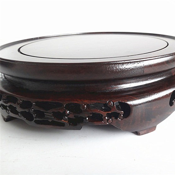 The teapot holder supporting a traditional Chinese teapot on a modern tea table