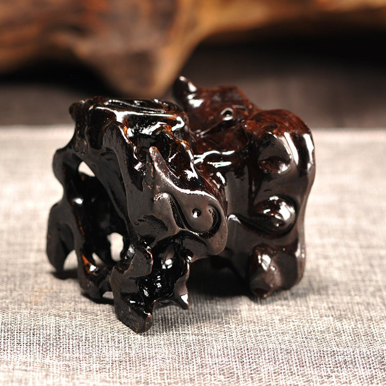 Close-up of black wood teapot stand showcasing unique textured surface