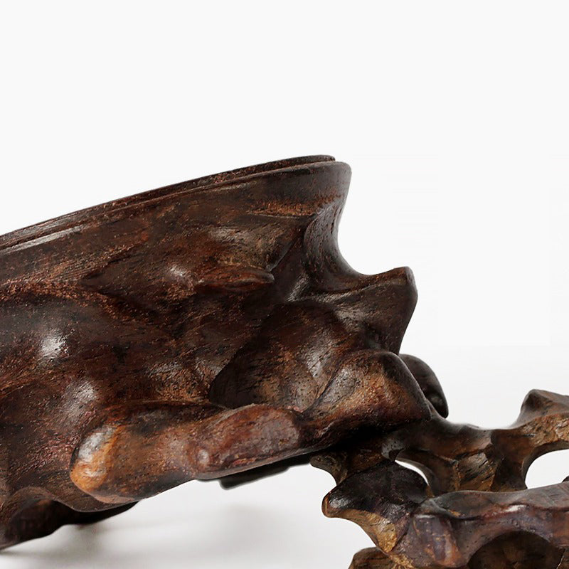 Close-up of Pau preto wood teapot stand highlighting textured surface and artistic stripe design