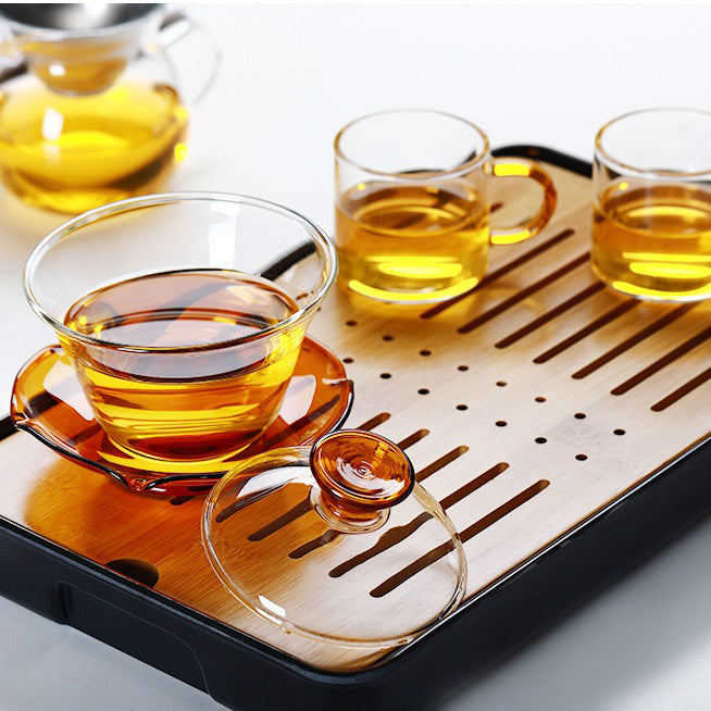 Using a gaiwan for tea brewing, pouring hot water into the glass gaiwan