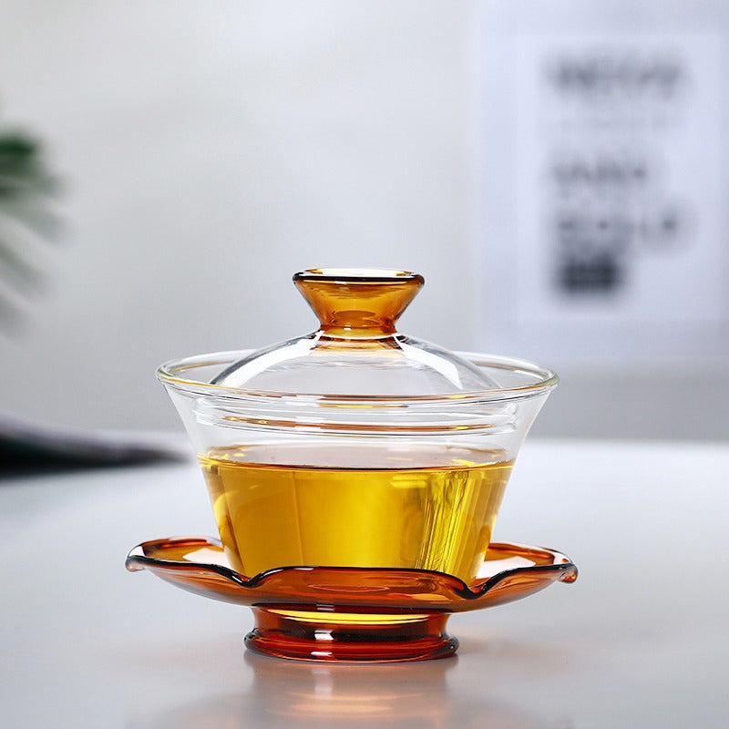 Using a gaiwan for tea brewing, pouring hot water into the glass gaiwan