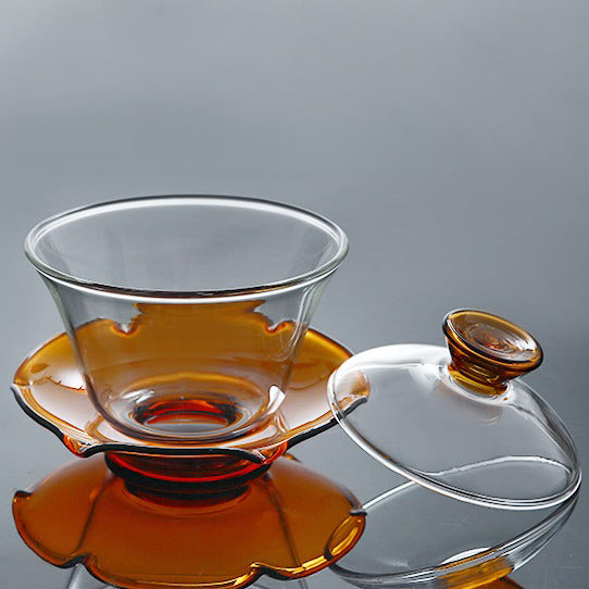 Using a gaiwan for tea brewing, pouring hot water into the glass gaiwan