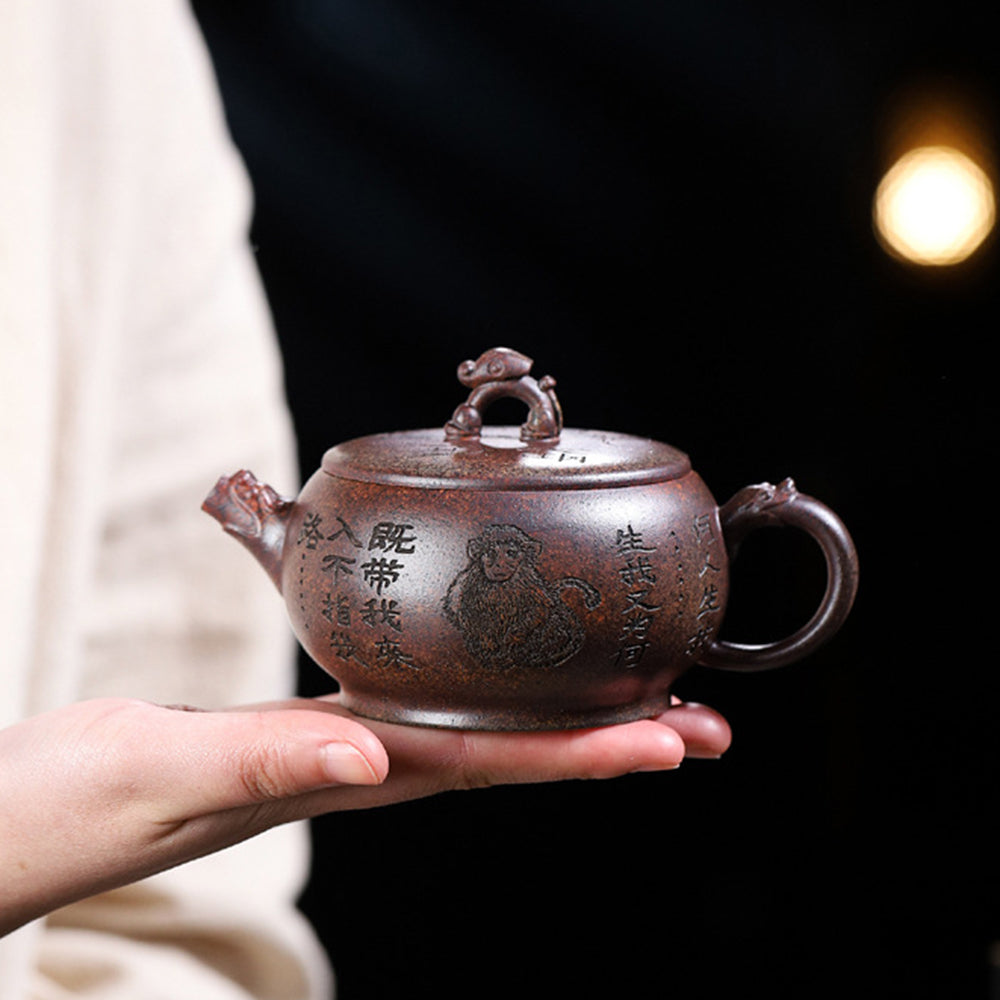 Close-up of handcrafted yixing purple clay monkey teapot showing detailed monkey sculpture on lid