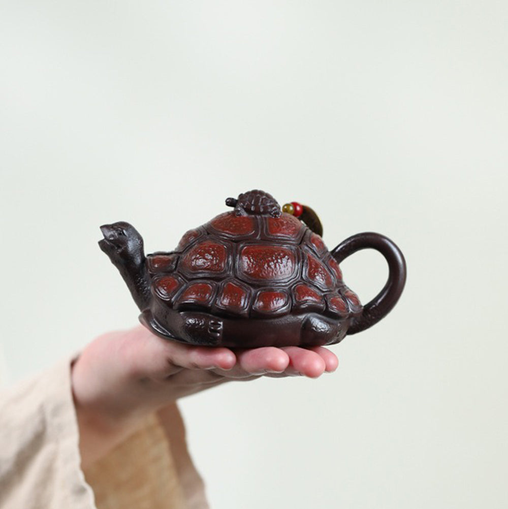 Purple clay turtle teapot displayed on a shelf for elegant home decoration
