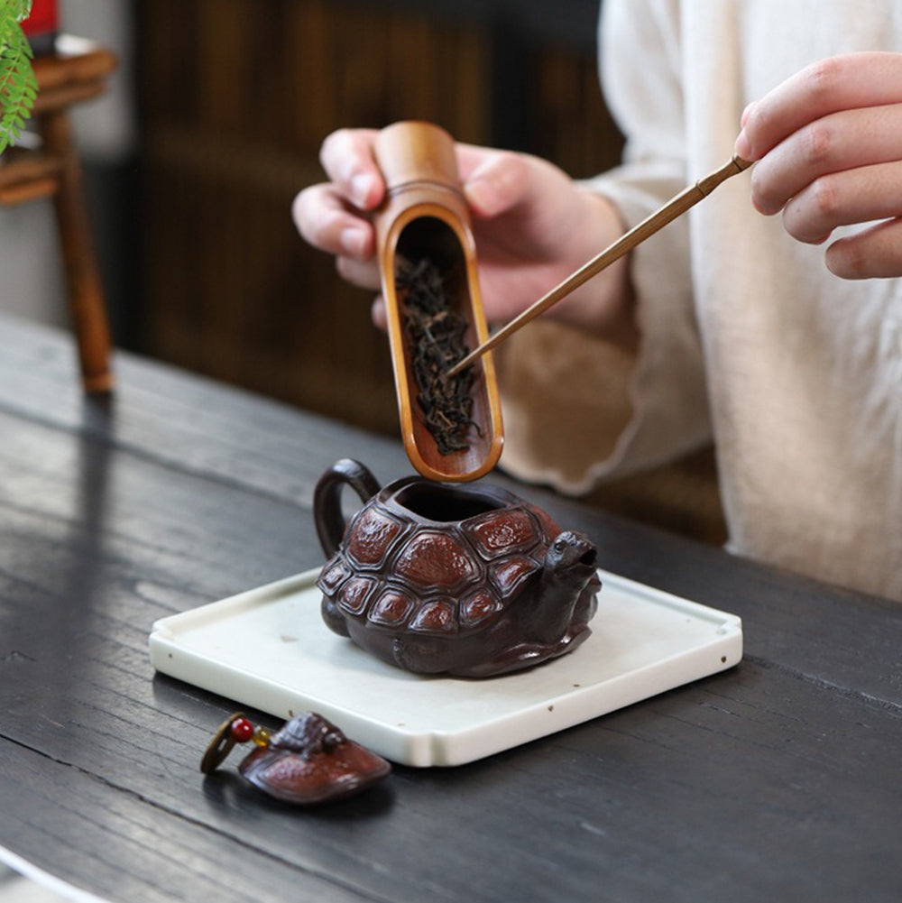 Yixing purple clay teapot being used to serve tea in a cozy setting