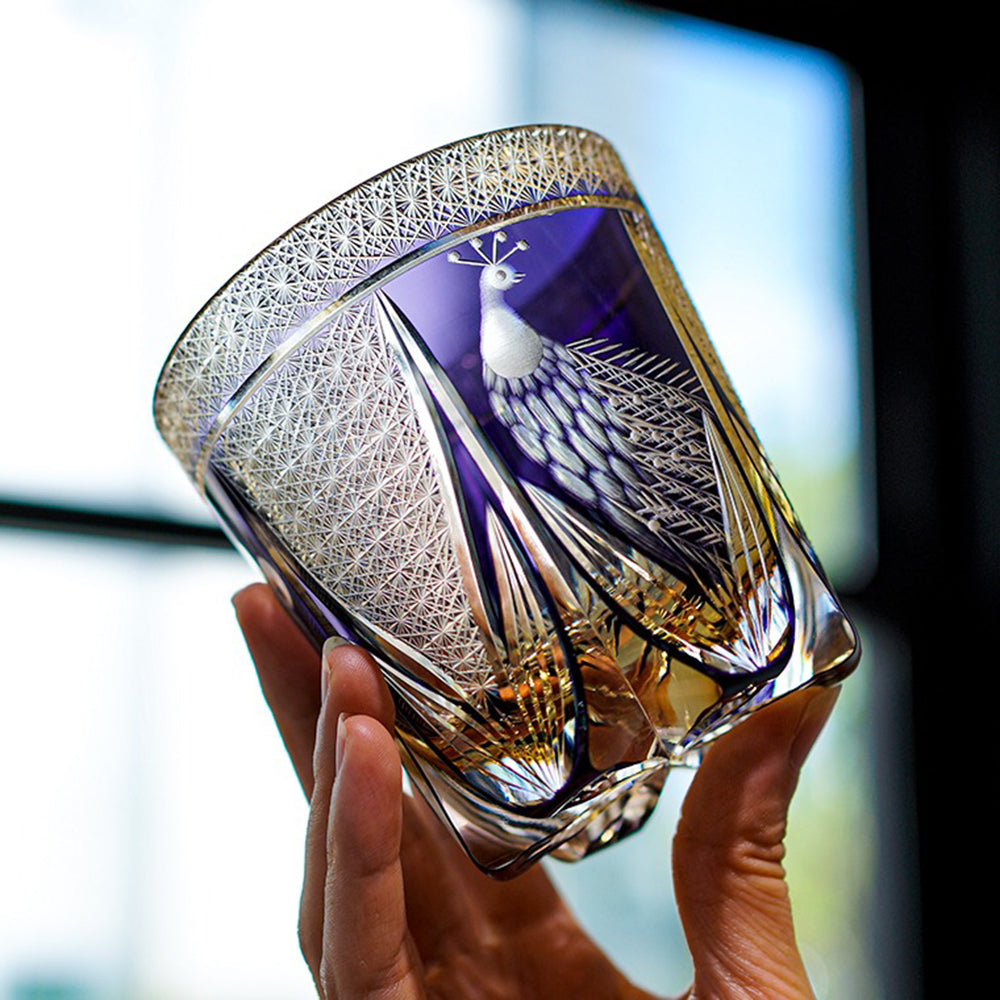 Close-up of handcrafted Edo Kiriko whisky glass showing peacock feather details under natural light.