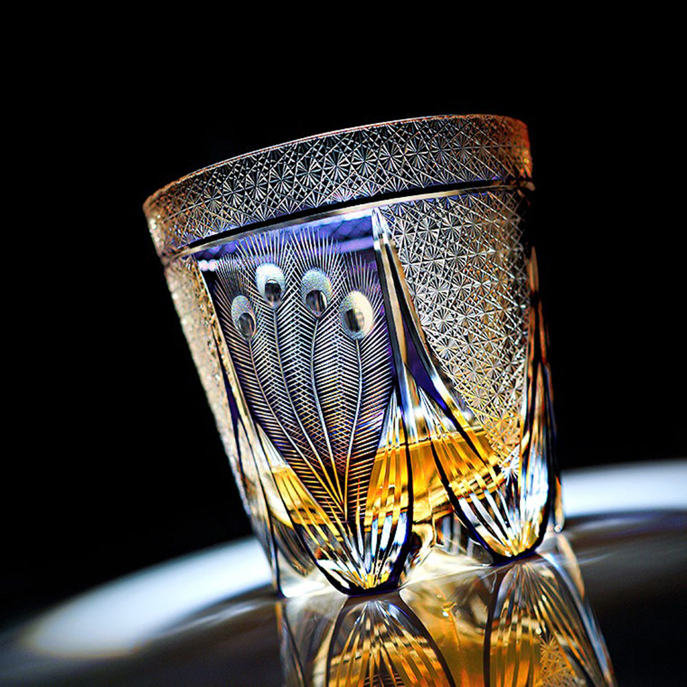 Close-up of handcrafted Edo Kiriko whisky glass showing peacock feather details under natural light.