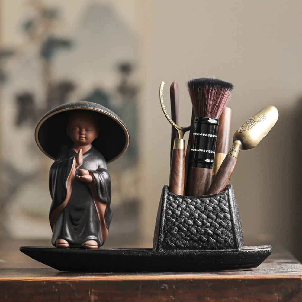 Close-up of ceramic boat tea set with monk, showcasing detailed craftsmanship