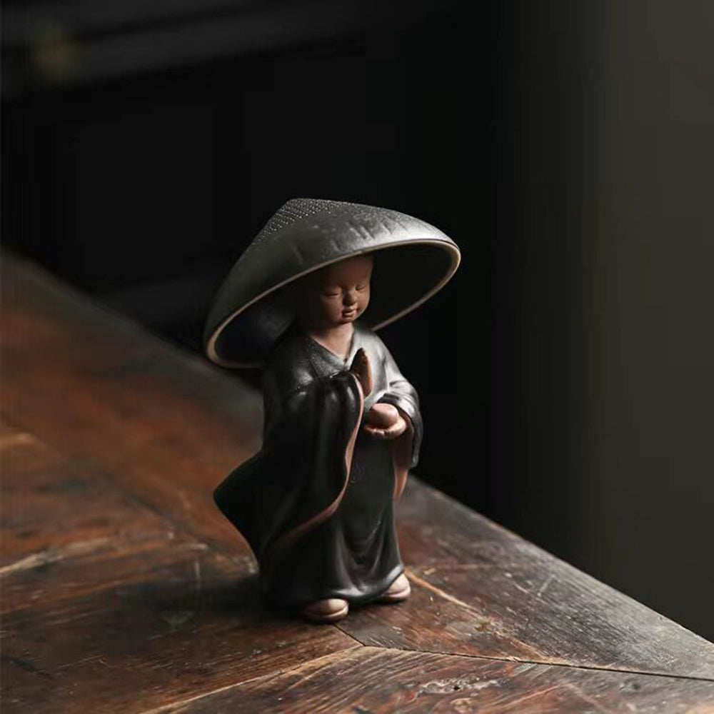 Close-up of ceramic boat tea set with monk, showcasing detailed craftsmanship