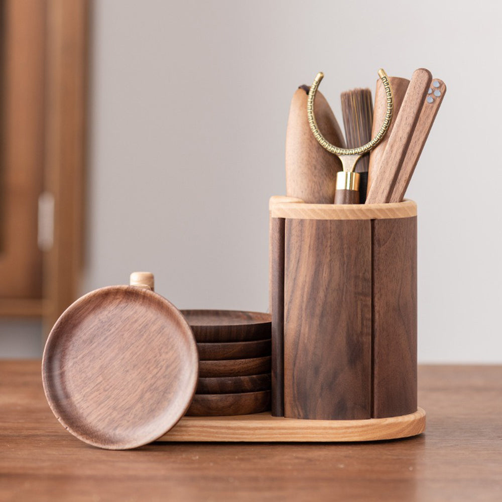 A close-up of the tea knife and teaspoon with copper details displayed on a walnut tray.