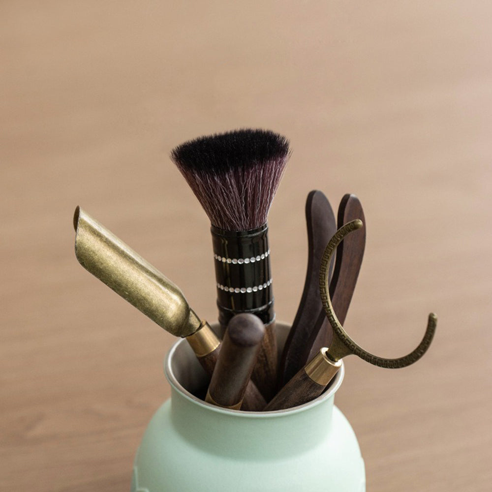 Close-up of the polished ebony handles of the tea utensils, highlighting craftsmanship and comfort.