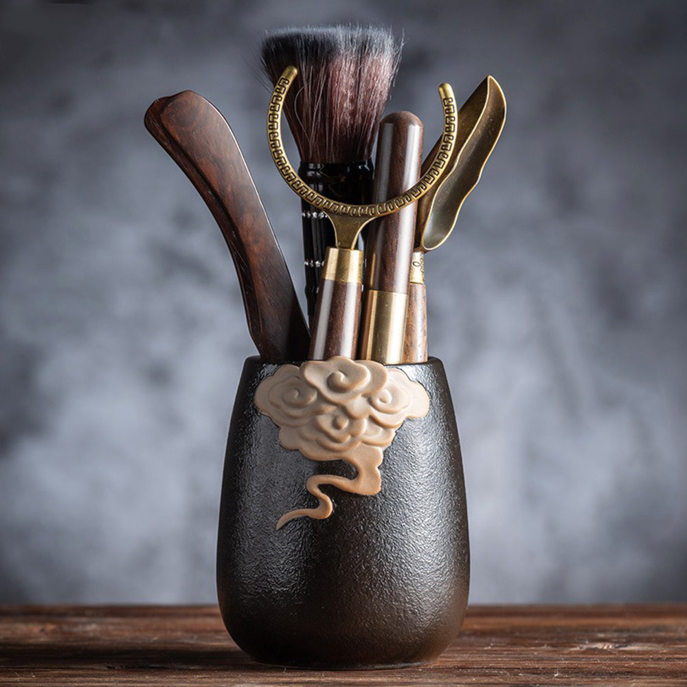 Tea ceremony setup featuring ceramic tea holder and ebony utensils, highlighting traditional design