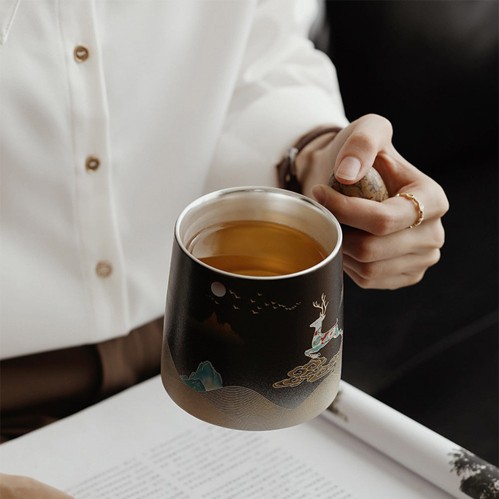 Close-up of ceramic tea mug with silver interior and gilded details, ideal for tea lovers