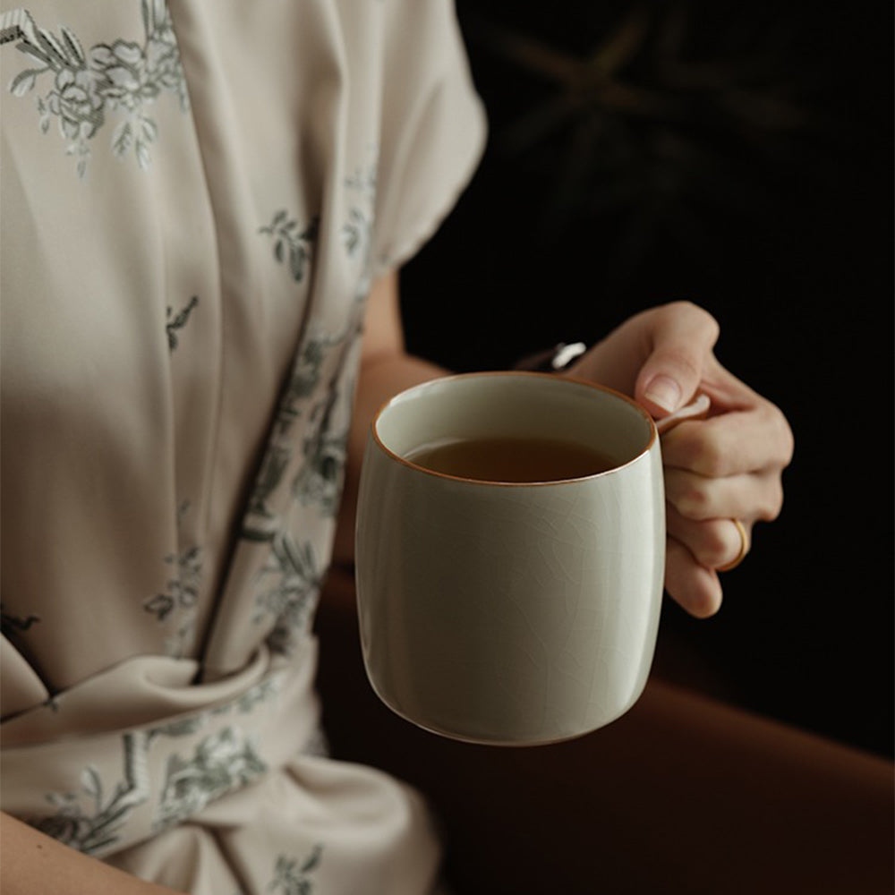 Close-up of beige glazed porcelain cup with intricate cicada wing texture.