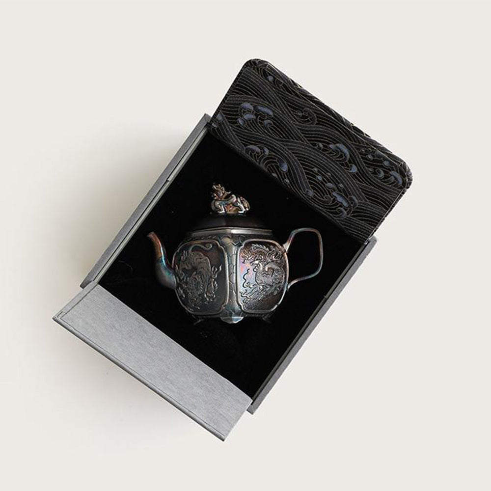 Close-up of the silver teapot with sacred beast design highlighting the intricate details.