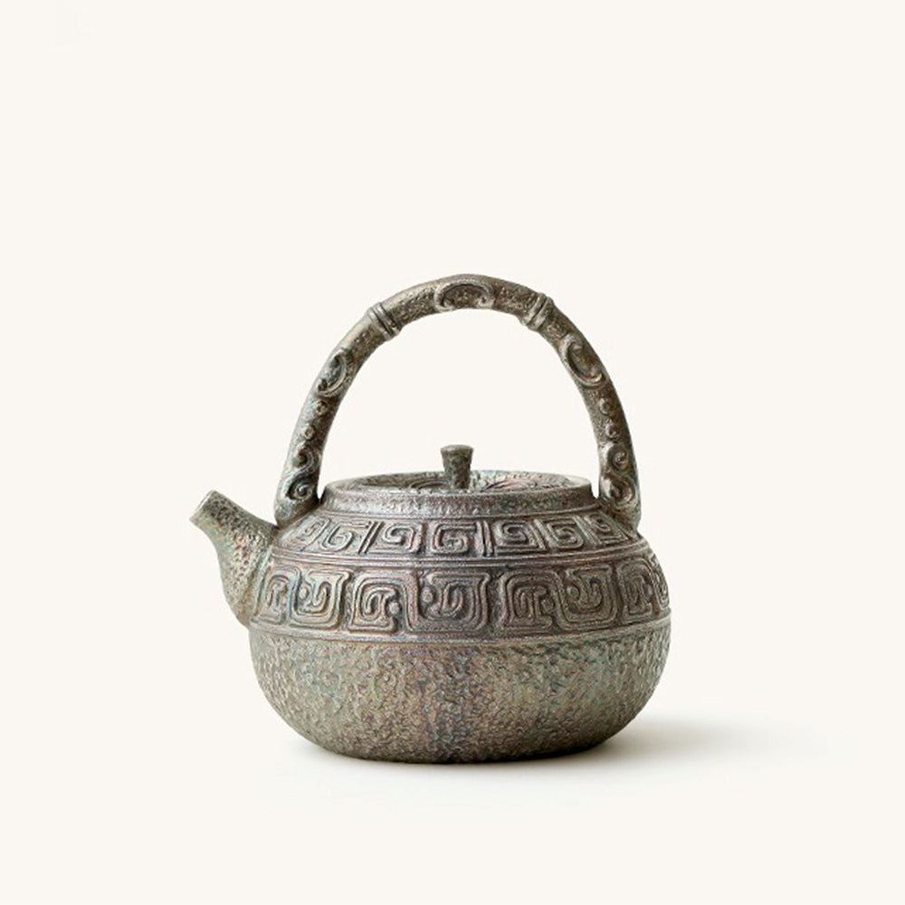 Close-up of antique silver-plated ceramic teapot showing intricate design and traditional Chinese characters