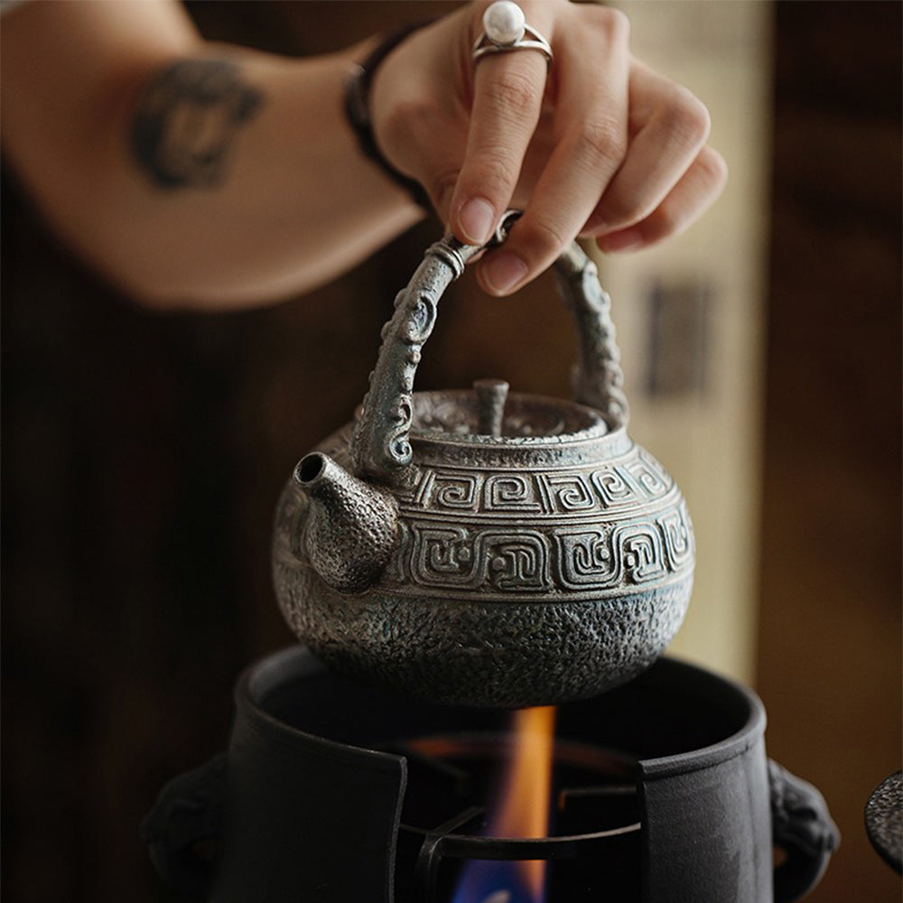 Close-up of antique silver-plated ceramic teapot showing intricate design and traditional Chinese characters