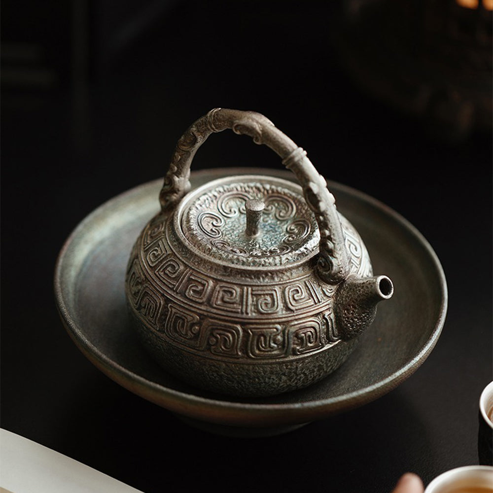 Tea being poured from a silver-plated ceramic teapot onto a cup, highlighting its elegant spout and handle