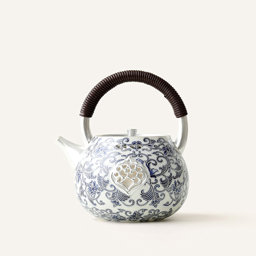 Close-up of blue and white porcelain Chinese teapot with silver accents, showing detailed craftsmanship