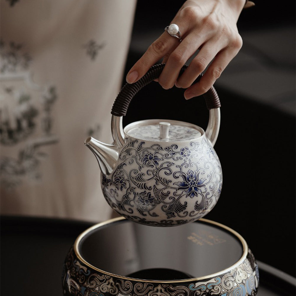 Close-up of blue and white porcelain Chinese teapot with silver accents, showing detailed craftsmanship