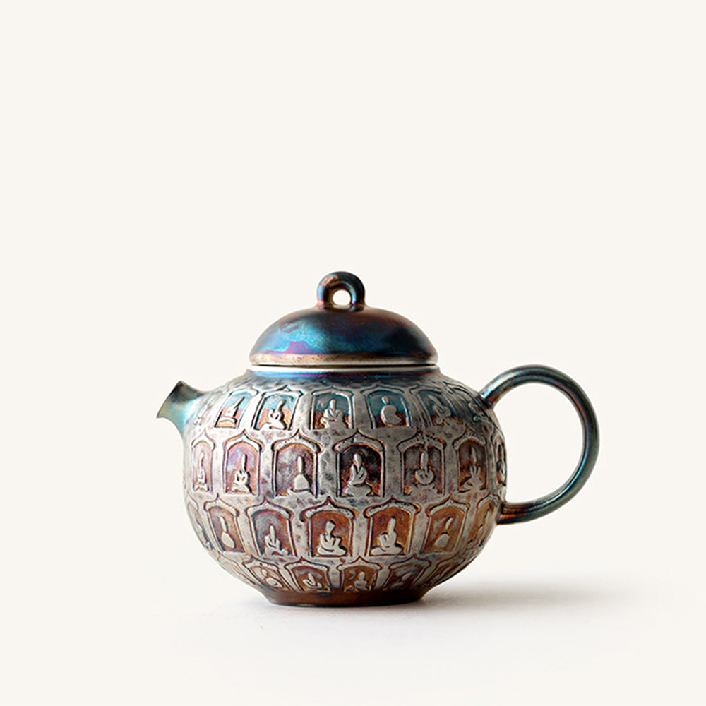 Close-up view of the artistic silver-plated Buddha teapot, highlighting intricate carvings.