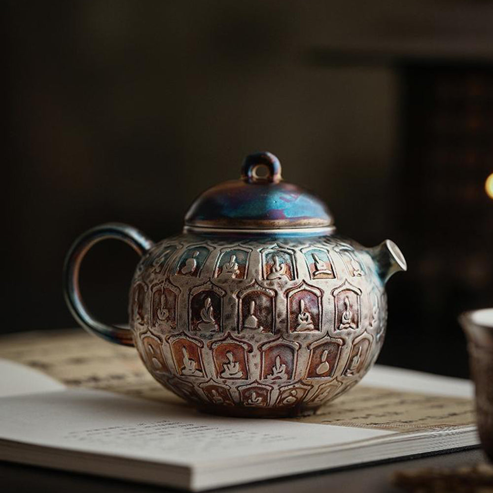 A colorful silver-plated ceramic Buddha teapot elegantly displayed in a gift box.