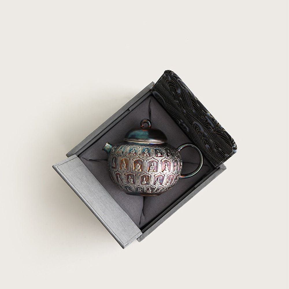 Close-up view of the artistic silver-plated Buddha teapot, highlighting intricate carvings.