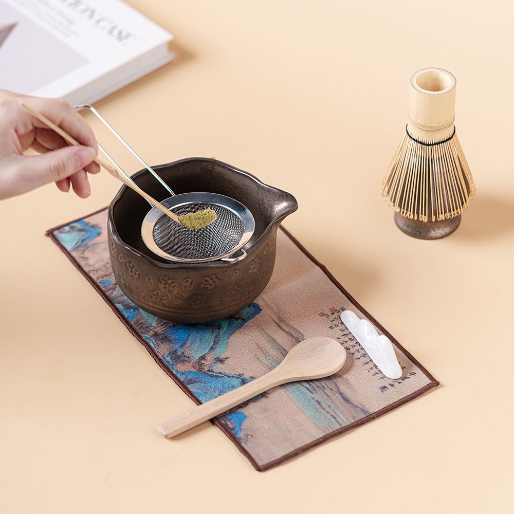 Set of matcha accessories including tea scoop, filter, and mug