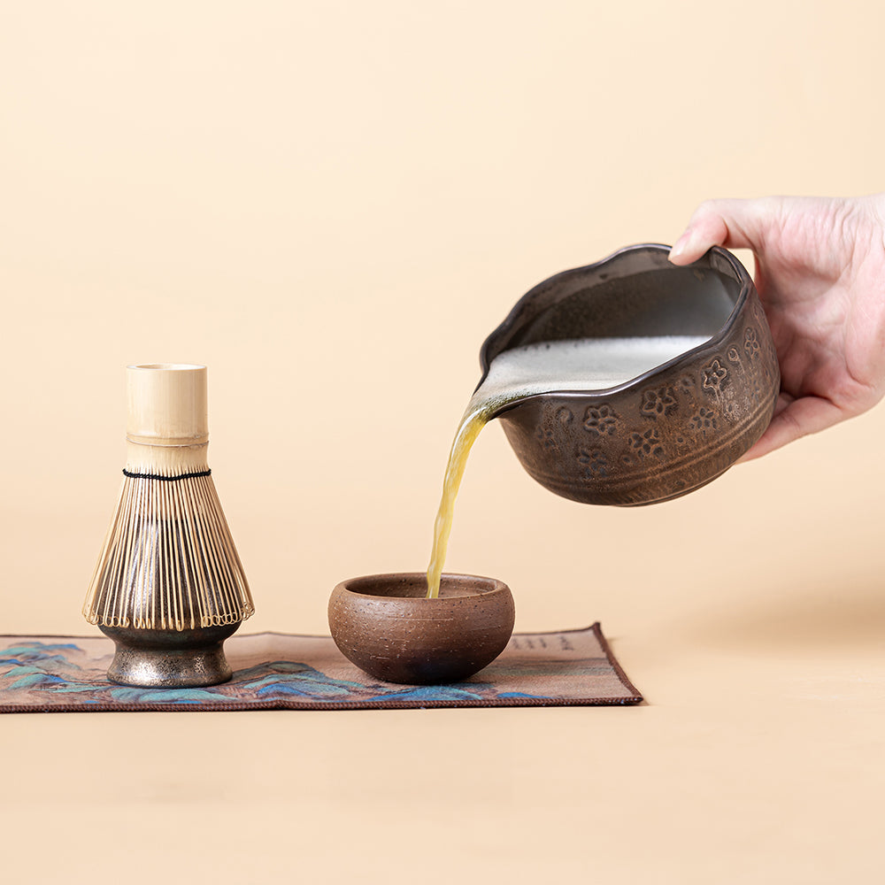 Traditional bamboo whisk and ceramic stand for tea ceremony