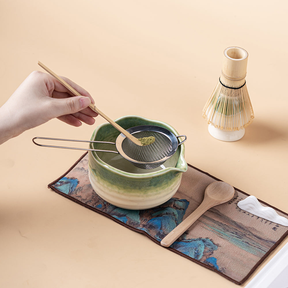 Close-up of kiln-glazed green matcha tea bowl with whisk