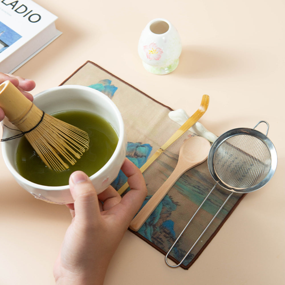 Premium bamboo whisk for creating matcha foam, shown in use