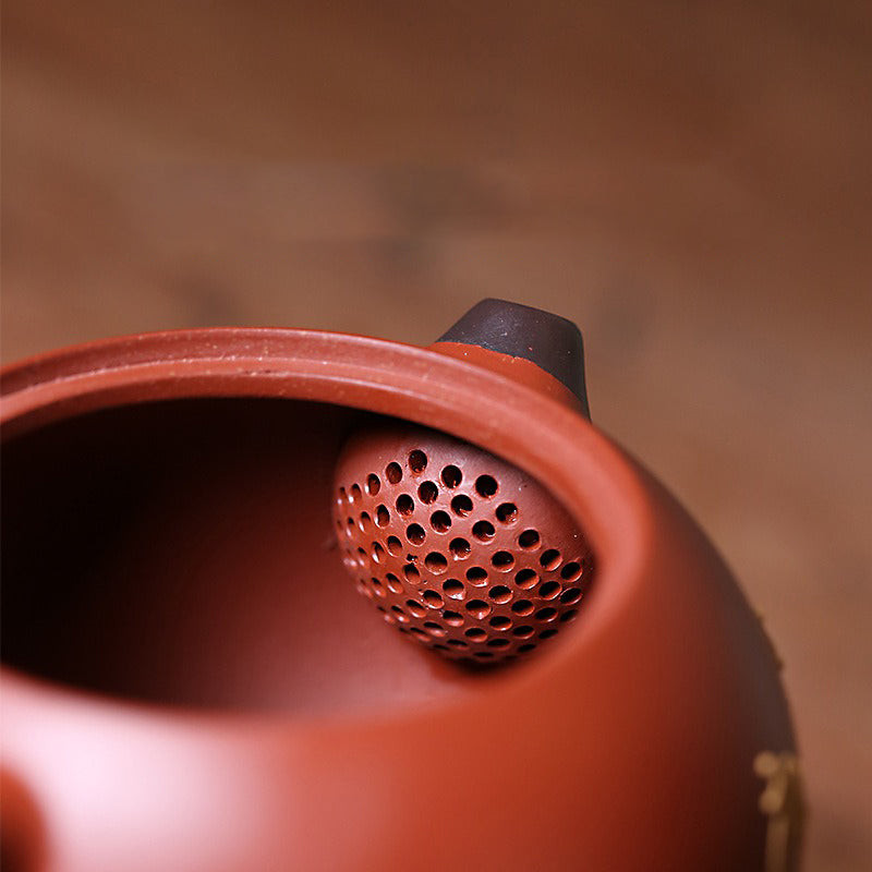 Yixing teapot in use, pouring tea into a cup, showcasing its functionality and elegance.