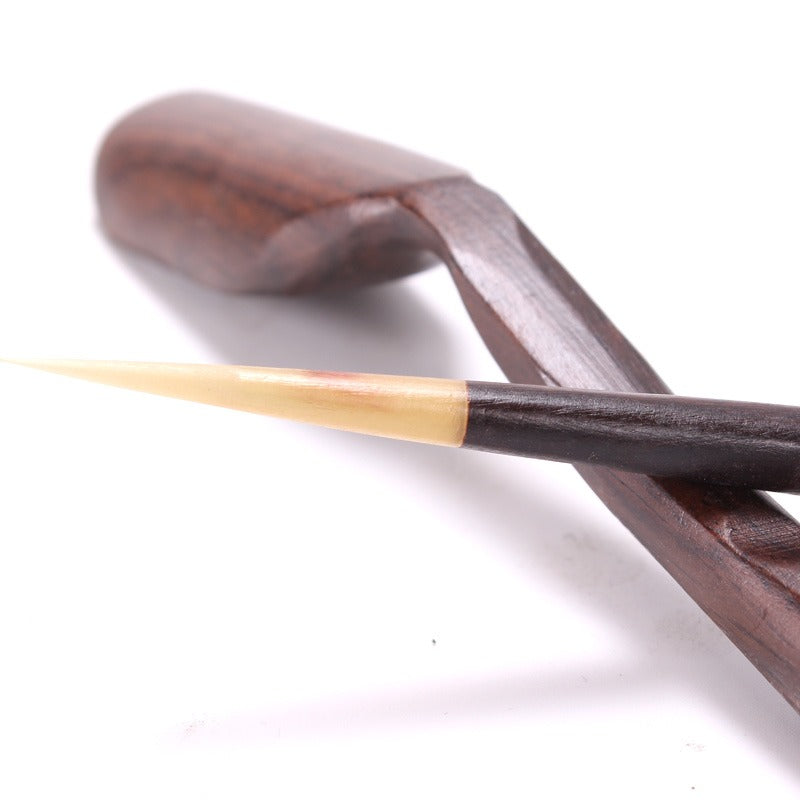 Close-up of the tea scoop, funnel, and tweezers from the Gong Fu tea utensil set.