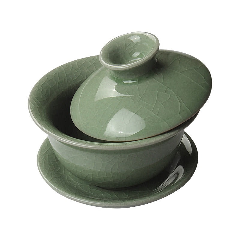 Side profile of celadon gaiwan in use for brewing loose leaf tea