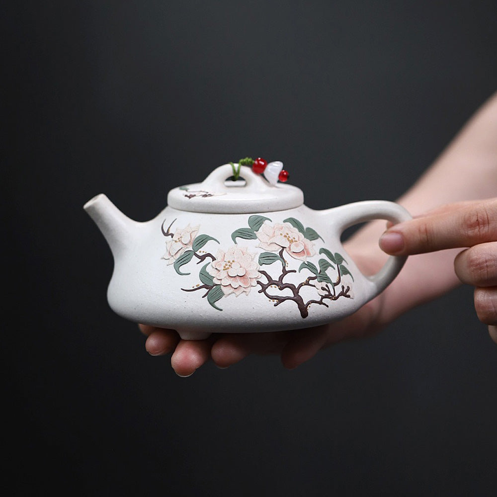 Front view of white clay peony Yixing teapot with intricate hand-painted design