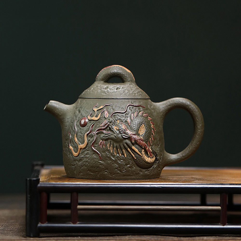 Elegant dark green clay teapot showcasing dragon design from a side angle.