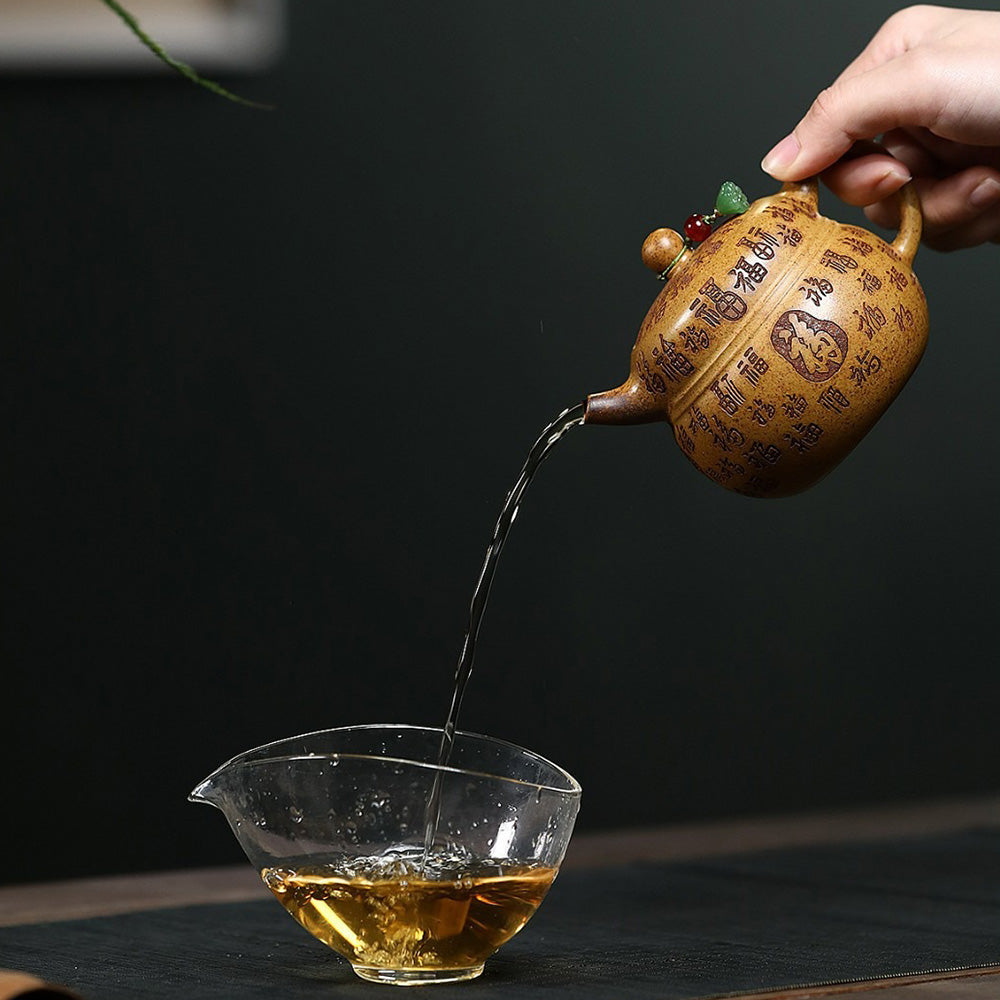 Tea being poured from the exquisite clay teapot into a cup, highlighting craftsmanship